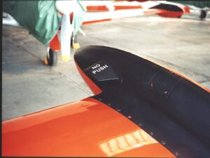 These re energize the airflow over the ailerons at high angles of attack, improving low speed lateral controllability, and reduce the tip tank from bouncing up and down whilst taxiing at full fuel capacity.