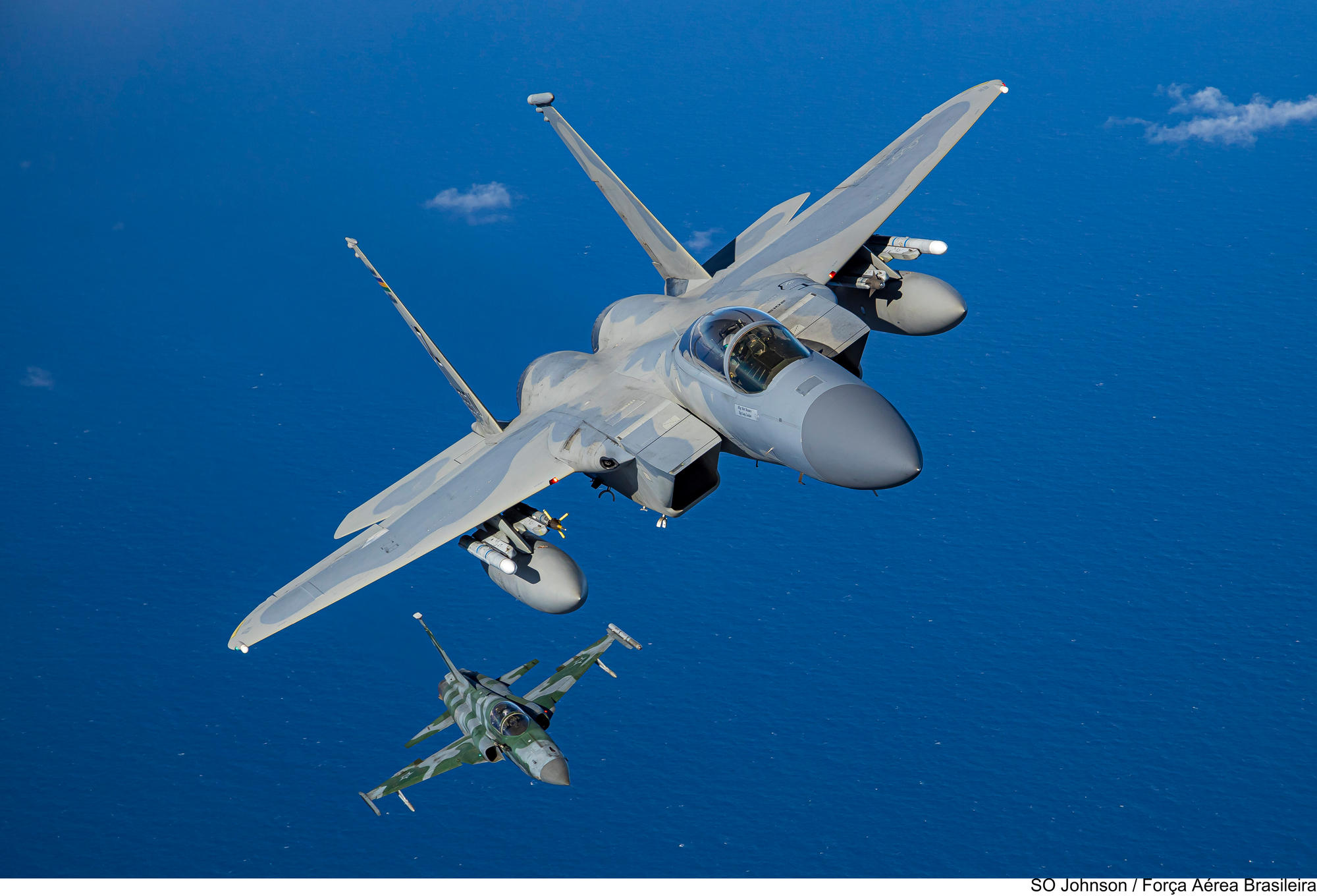 A US Air National Guard F-15C "Eagle" banks right over the Atlantic followed by a FAB F-5EM. At CRUZEX 2024
