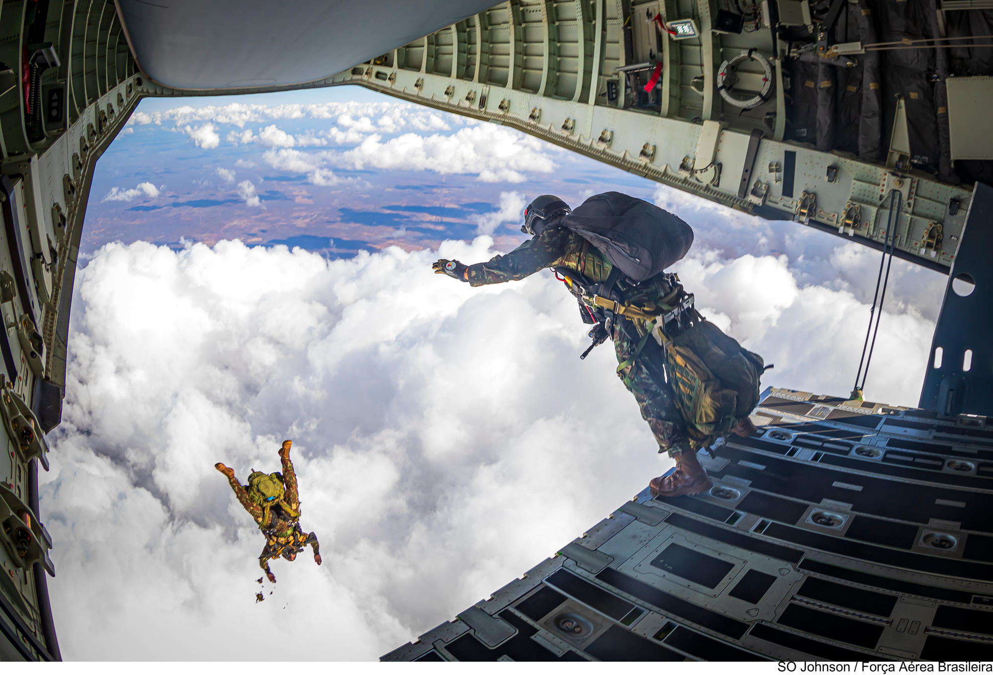 Brazilian paratroopers jumping out of a FAB KC-390.